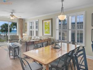 een woonkamer met een houten tafel en stoelen bij SMP 209 - Large 4 Bedroom Beachfront Condo in Fort Walton Beach