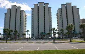 two tall buildings in a parking lot with palm trees at 12th Floor Bchfront Condo-Amazing Views! Sleeps 8! in Navarre