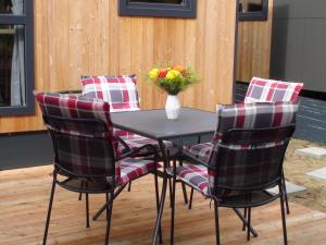 a table with four chairs and a vase with flowers at Holiday Home Toni by Interhome in Wemding