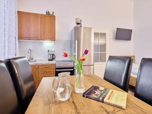 a kitchen with a wooden table with flowers in a vase on it at Apartment Villa Belvedere-4 by Interhome in Janske Lazne