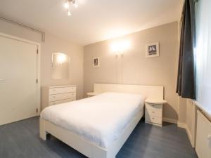 Dormitorio blanco con cama blanca y vestidor en Apartment Seaview Getaway Belgium by Interhome, en Blankenberge