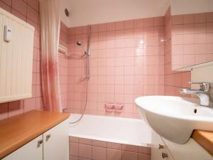 y baño de color rosa con lavabo y ducha. en Apartment Seaview Getaway Belgium by Interhome, en Blankenberge