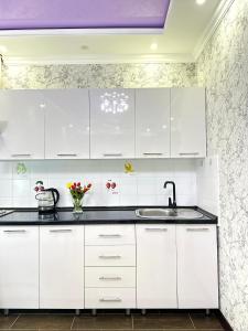 阿克套的住宿－ЖК Тыныштык，白色的厨房配有白色橱柜和水槽