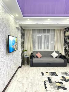 Habitación con cama y TV en la pared. en ЖК Тыныштык, en Aktau