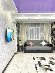 a room with a bed and a tv on a wall at ЖК Тыныштык in Aktau