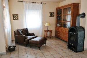 sala de estar con silla y estufa de leña en Chalet Paraiso, en Sella