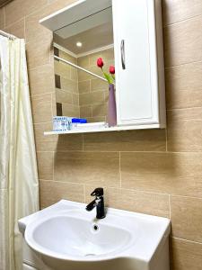 y baño con lavabo blanco y espejo. en ЖК Тыныштык, en Aktau