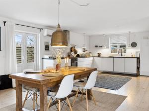 - une cuisine avec une table en bois et des placards blancs dans l'établissement Holiday Home Kielo - 650m from the sea in Sealand by Interhome, à Nykøbing Sjælland