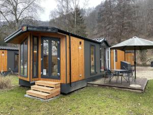 a tiny house with a table and an umbrella at Holiday Home Tiny Haus Tania by Interhome in Riedenburg