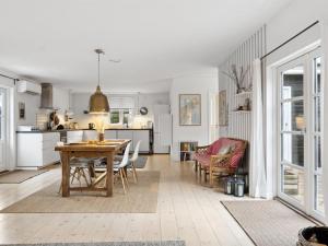 Il comprend une cuisine et un salon avec une table et des chaises. dans l'établissement Holiday Home Kielo - 650m from the sea in Sealand by Interhome, à Nykøbing Sjælland