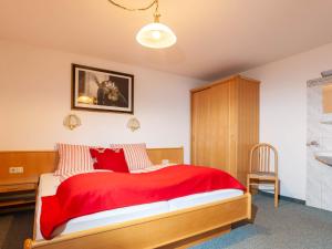 a bedroom with a red bed and a chair at Apartment Aurora Apartment Top II by Interhome in Kappl +21 photos