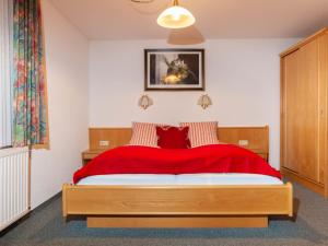a bedroom with a large bed with a red blanket at Apartment Aurora Apartment Top II by Interhome in Kappl