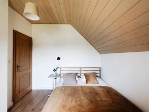 a bedroom with a large bed with a wooden ceiling at Holiday Home Domek pod Szarowym Lasem by Interhome in Wisła