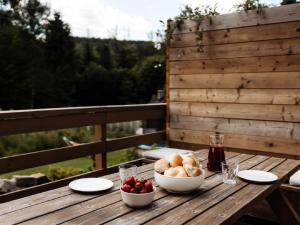 a wooden table with a bowl of bread and a bowl of fruit at Holiday Home Domek pod Szarowym Lasem by Interhome in Wisła