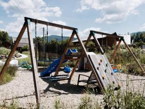 a playground with a slide and a swing set at Holiday Home Domek pod Szarowym Lasem by Interhome in Wisła