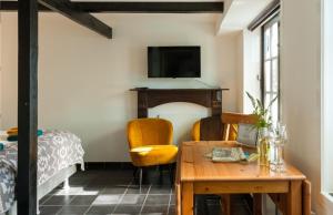 エンクホイゼンにあるBed and Breakfast Enkhuizenのベッド、テーブル、テレビが備わる客室です。