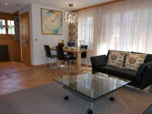 een woonkamer met een bank en een tafel bij Apartment Chalet Pfingstrose by Interhome in Grindelwald