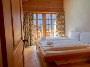 een slaapkamer met een bed en een raam met uitzicht bij Apartment Chalet Pfingstrose by Interhome in Grindelwald