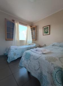 1 dormitorio con 2 camas y ventana en Casiopea Apart en San Fernando del Valle de Catamarca