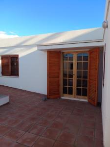 un patio exterior de una casa con puertas de madera en Casiopea Apart, en San Fernando del Valle de Catamarca
