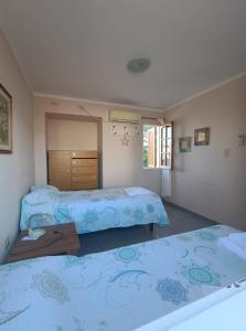 a bedroom with two beds and a table in it at Casiopea Apart in San Fernando del Valle de Catamarca