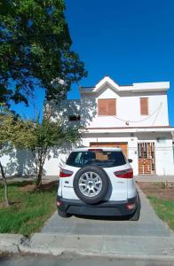 a white car parked in front of a house at Casiopea Apart in San Fernando del Valle de Catamarca