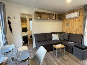 ein Wohnzimmer mit einem Sofa und einem Tisch in der Unterkunft Holiday Home Auszeit Am See by Interhome in Wemding