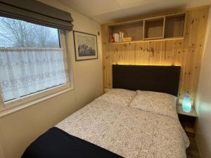 Schlafzimmer mit einem Bett und einem Fenster in der Unterkunft Holiday Home Auszeit Am See by Interhome in Wemding