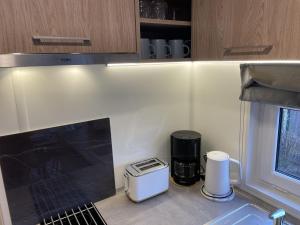 a kitchen with a sink and a coffee maker at Holiday Home Tiny Haus Auszeit Am See by Interhome in Wemding +16 photos