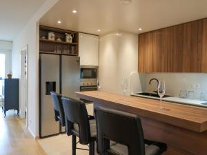 uma cozinha com um bar com cadeiras e copos de vinho em Apartment Petit Saconnex 28A by Interhome em Genebra