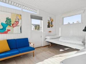 - une chambre avec un lit et un canapé bleu dans l'établissement Holiday Home Sylvia - 450m from the sea in Djursland and Mols by Interhome, à Rønde