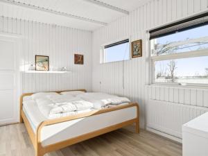 - une chambre blanche avec un lit dans une pièce dotée d'une fenêtre dans l'établissement Holiday Home Sylvia - 450m from the sea in Djursland and Mols by Interhome, à Rønde
