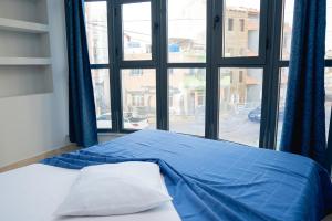 Bett in einem Zimmer mit einem großen Fenster in der Unterkunft Apartamento Santo Antonio I - T3 in Praia