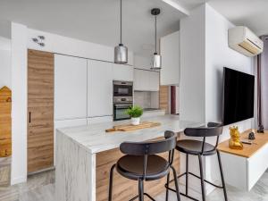 een keuken met witte kasten en barkrukken bij Apartment Parque Botanico by Interhome in Estepona