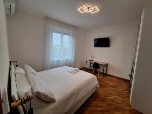 a bedroom with a bed and a desk with a television at Casa Vanessa in Arezzo