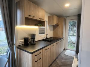 a small kitchen with wooden cabinets and a window at Holiday Home Tiny Haus Antonia by Interhome in Riedenburg