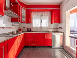 - une cuisine rouge avec des placards rouges et un évier dans l'établissement Holiday Home Villa Rosales by Interhome, à Gornal