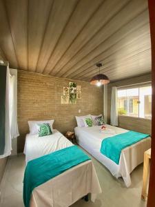 路易斯科雷亞的住宿－Luar do Maramar Chalés，一间卧室设有两张床和窗户。