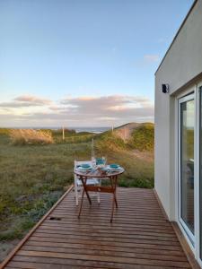 a table on a deck with a view of a field at La Casa de Caro Playa in Mar de Cobo