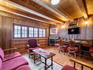 sala de estar con paredes de madera, mesa y sillas en Holiday Home Le Tre Cime by Interhome, 