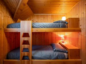 2 beliches num chalé de madeira com uma escada em Holiday Home Le Tre Cime by Interhome 