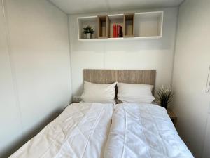 een slaapkamer met een bed met een wit dekbed bij Holiday Home Tiny Haus Schleusenblick by Interhome in Riedenburg