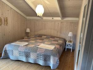 - une chambre avec un lit dans une pièce dotée de murs en bois dans l'établissement Holiday Home Santeri - 180m from the sea in NE Jutland by Interhome, à Strandby