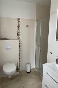 a white bathroom with a toilet and a shower at Urlaub am Plätlinsee Haus Leonore in Wustrow