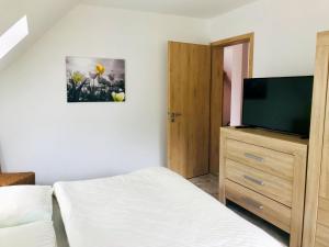 a bedroom with a bed and a flat screen tv at Urlaub am Plätlinsee Haus Leonore in Wustrow