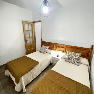a bedroom with two beds and a chandelier at Bajo Izquierda el Wiro in Puerto