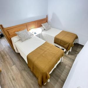 una habitación con dos camas y un sofá en Bajo Izquierda el Wiro, en Puerto