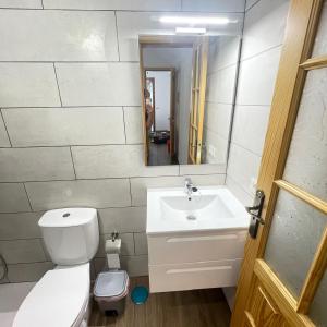 a bathroom with a toilet and a sink and a mirror at Bajo Izquierda el Wiro in Puerto