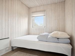 een bed in een kamer met een raam bij Holiday Home Beske - 130m from the sea in SE Jutland by Interhome in Odder