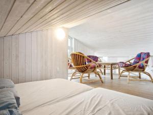 een slaapkamer met 2 stoelen en een tafel en een bed bij Holiday Home Beske - 130m from the sea in SE Jutland by Interhome in Odder
